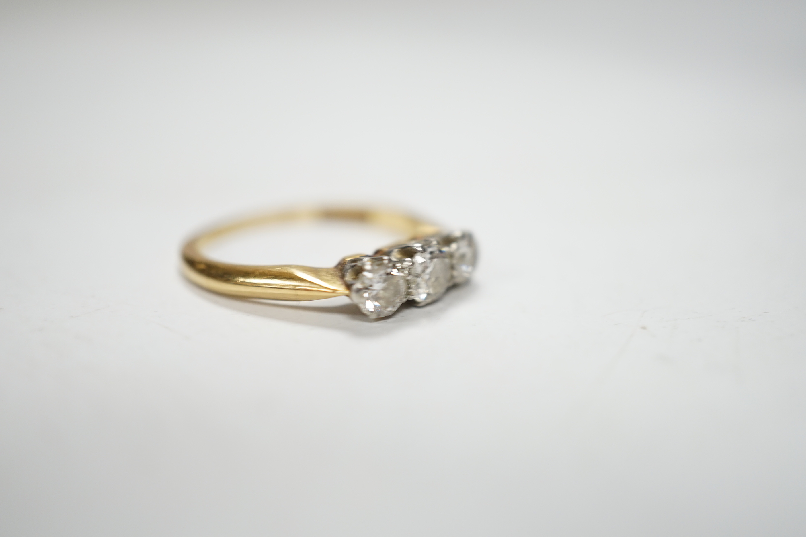 An 18ctct & plat, three stone diamond set ring, size L, gross weight 3.1 grams.